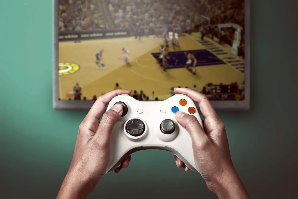 game console controller playing sports game on the television